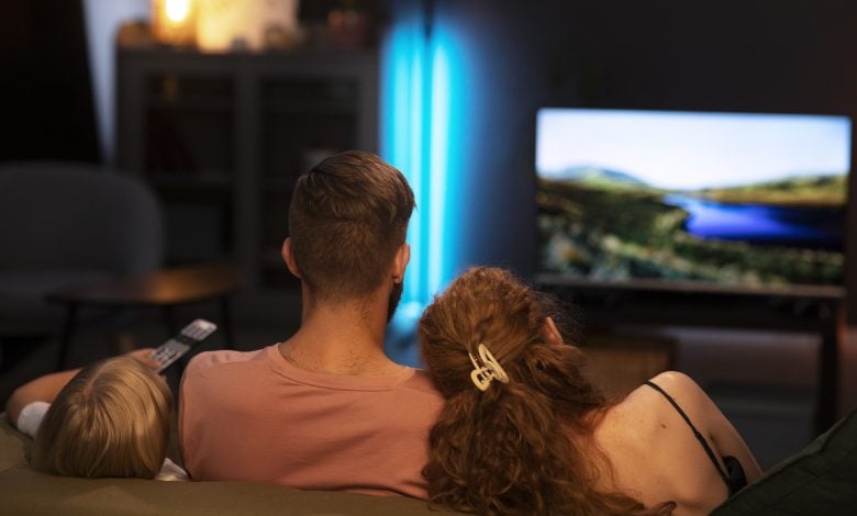 back view family watching tv