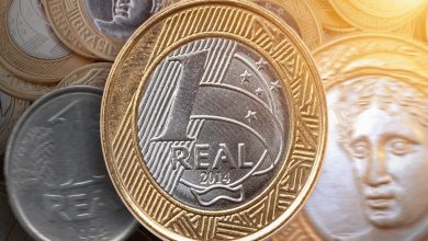 Moeda brasileira de 1 Real de 2014 com detalhes metálicos dourados e prateados.