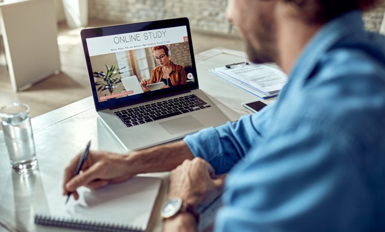 Estudante assistindo aula online e tomando notas